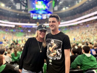 A woman and a teenager pose for a photo inside a sports stadium.